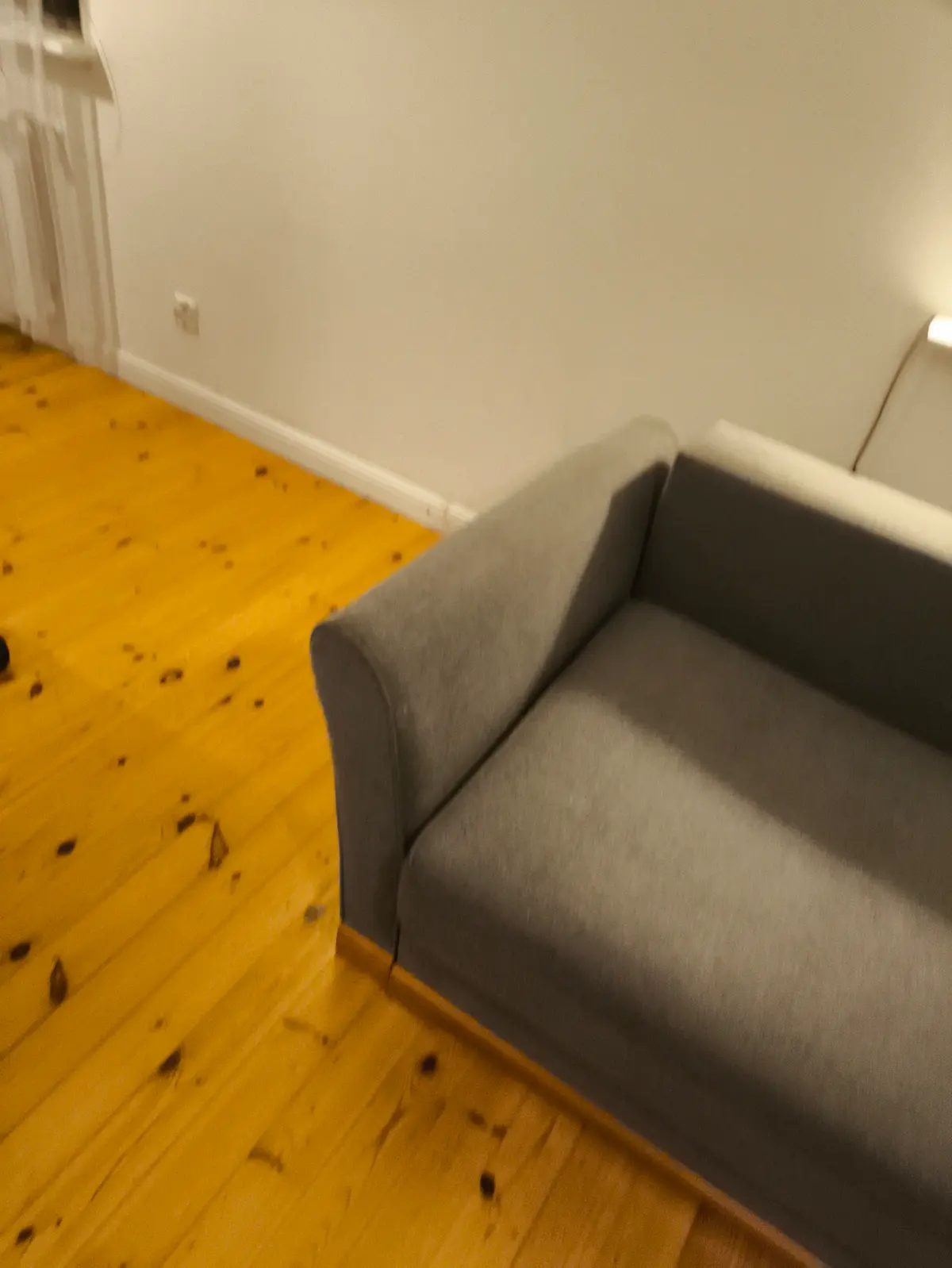 Szara sofa z zaokrąglonymi podłokietnikami po praniu ekstrakcyjnym — tkanina bez plam, kolor odzyskany. Pranie kanapy Grudziądz, SofaGo