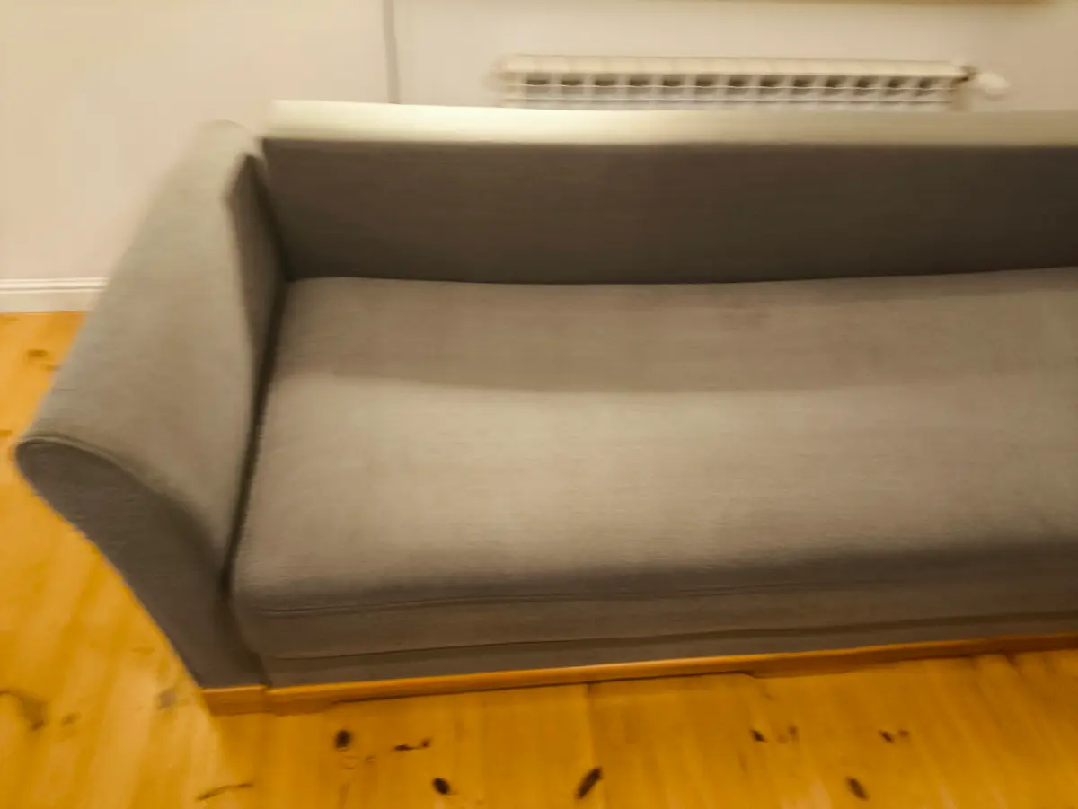 Szara sofa z zaokrąglonymi podłokietnikami po praniu ekstrakcyjnym — tkanina bez plam, kolor odzyskany. Pranie kanapy Katowice, SofaGo