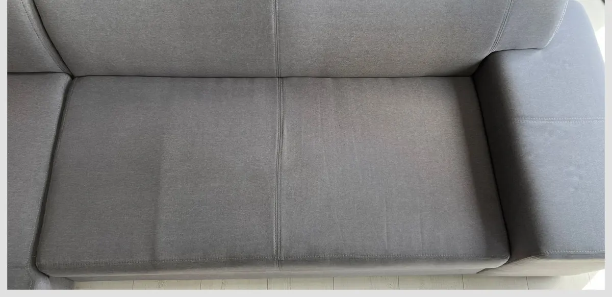 Szara sofa po praniu ekstrakcyjnym — tkanina bez plam, kolor odzyskany. Pranie kanapy Legnica, SofaGo