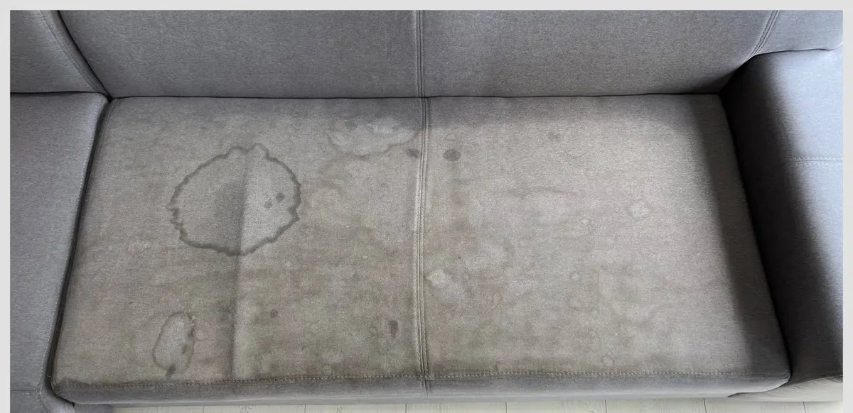 Szara sofa przed praniem — okrągła plama na siedzisku. Pranie kanapy Legnica, SofaGo