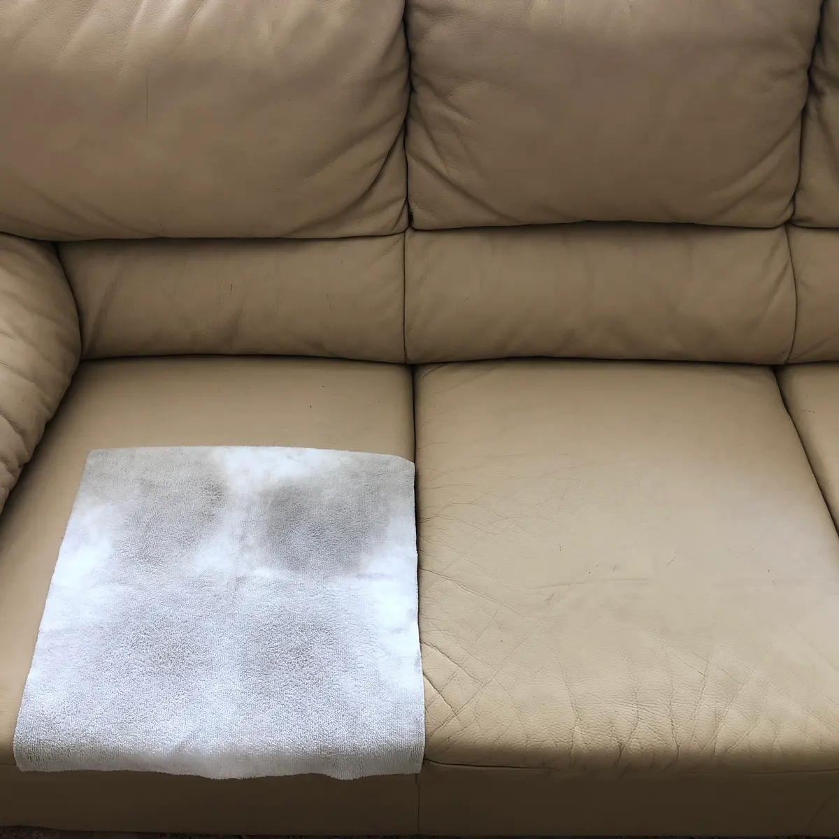Beżowa skórzana sofa w trakcie czyszczenia — umyty fragment siedziska obok zabrudzonego. Czyszczenie skórzanej kanapy Piła, SofaGo