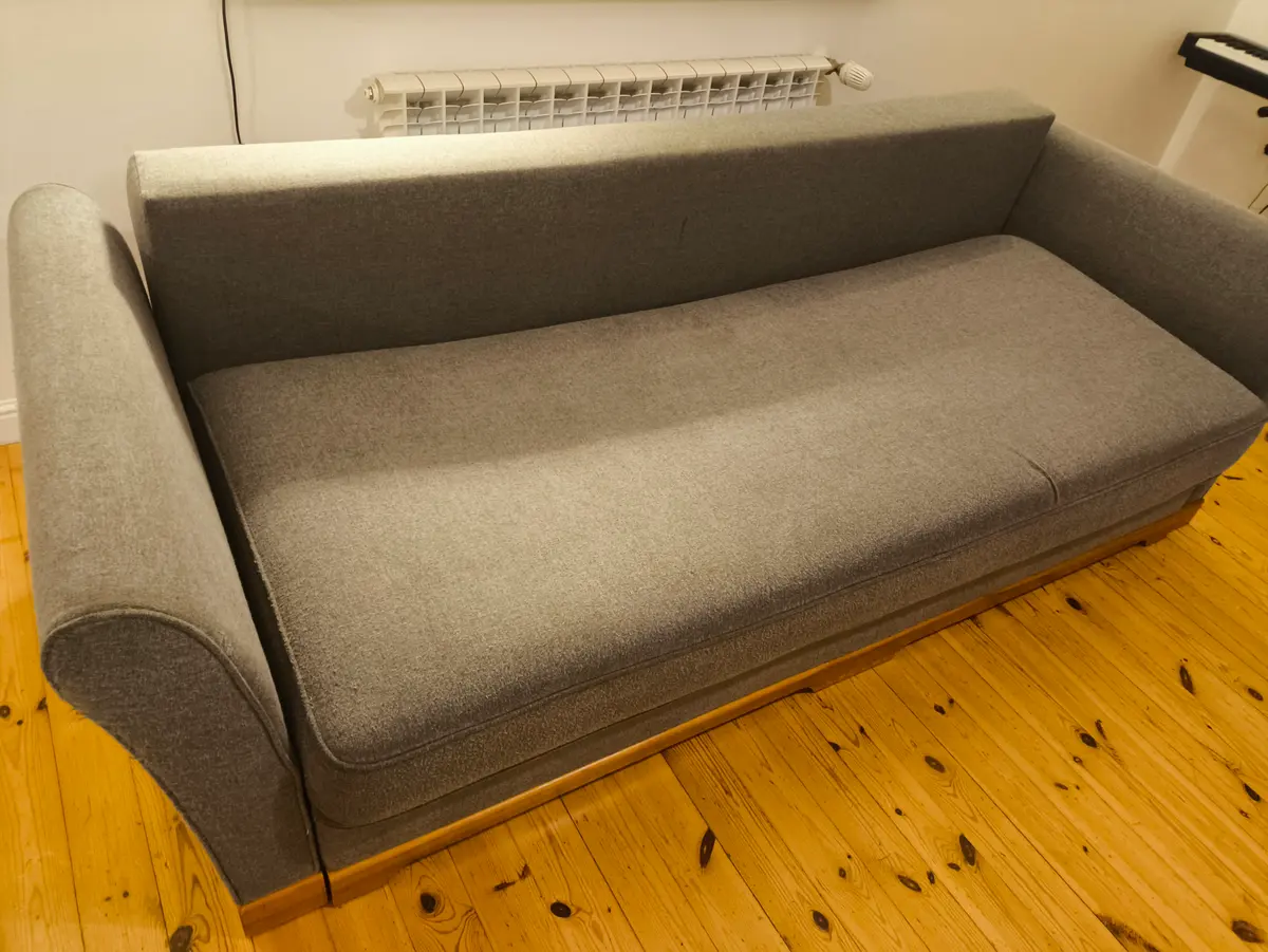 Szara sofa z zaokrąglonymi podłokietnikami po praniu ekstrakcyjnym — tkanina bez plam, kolor odzyskany. Pranie kanapy Poznań, SofaGo